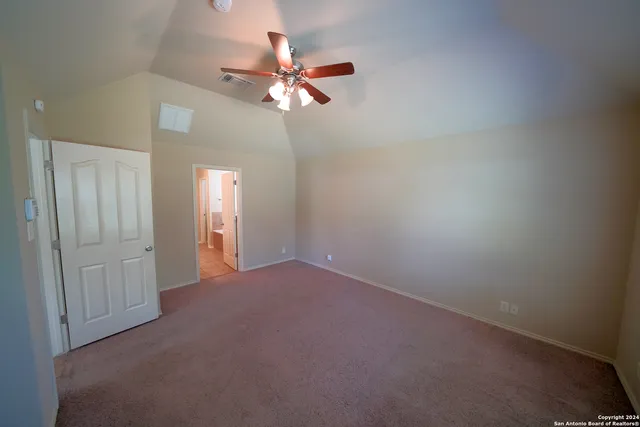 a view of an empty room with a chandelier fan