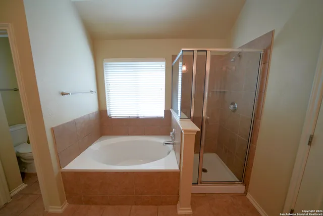 a bathroom with a tub shower and vanity