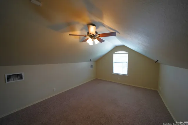 an empty room with a window and a ceiling fan