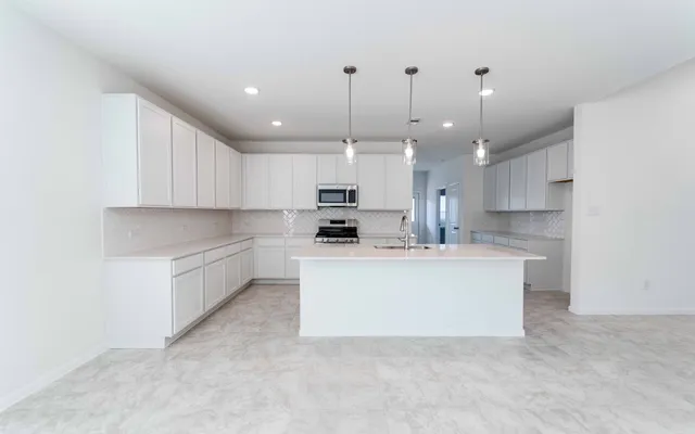 a kitchen with kitchen island a sink stainless steel appliances and cabinets