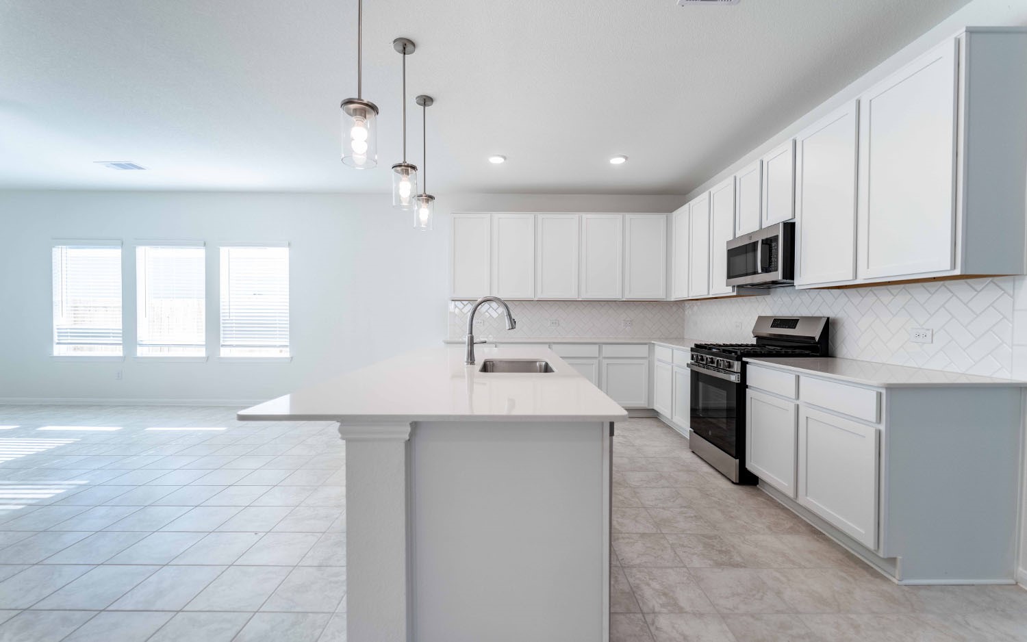 428 Monarch Trail Huntsville, TX 77340 - Photo 7 of 16 a kitchen with kitchen island granite countertop a sink a stove a microwave and a refrigerator