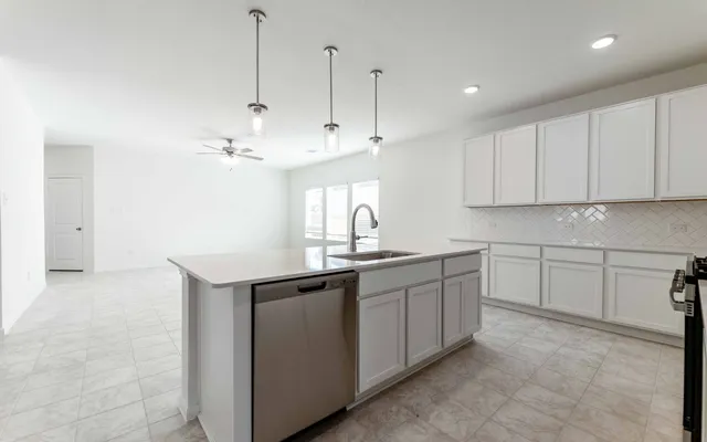 a kitchen with kitchen island white cabinets appliances and a sink