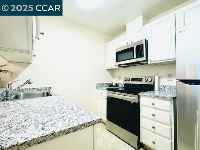 a kitchen with stainless steel appliances granite countertop a stove a sink and a microwave