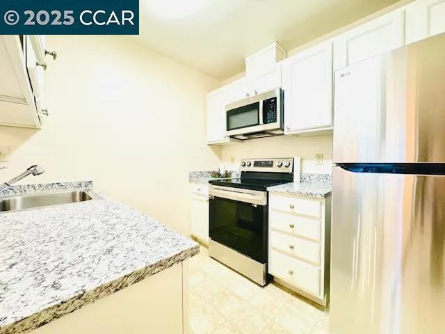 a kitchen with granite countertop a sink and a stove top oven
