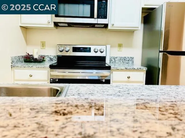 a living room with a stove and a refrigerator