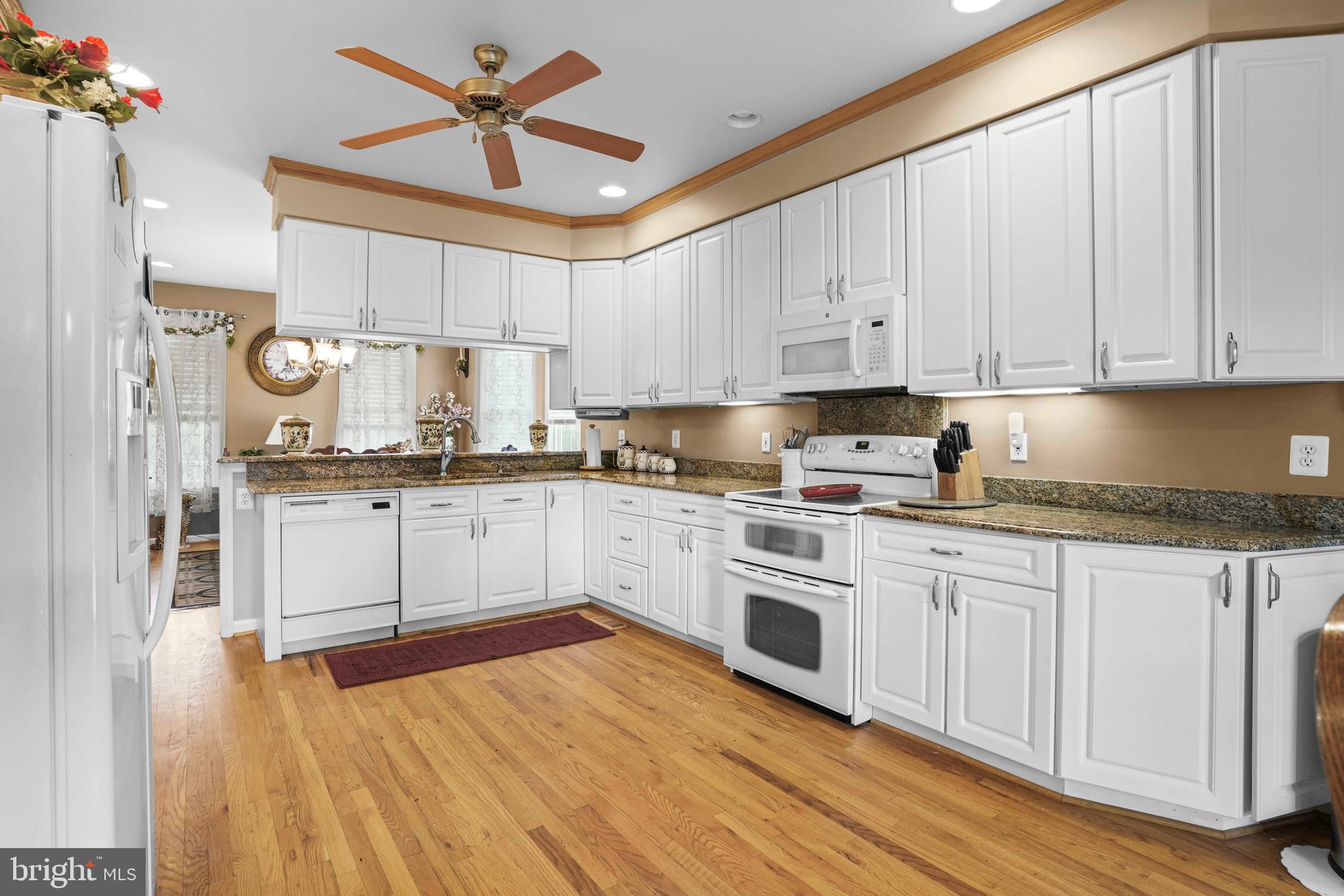 94 Friendship Road Friendship, MD 20758 - Photo 7 of 40 a kitchen with granite countertop white cabinets and white appliances