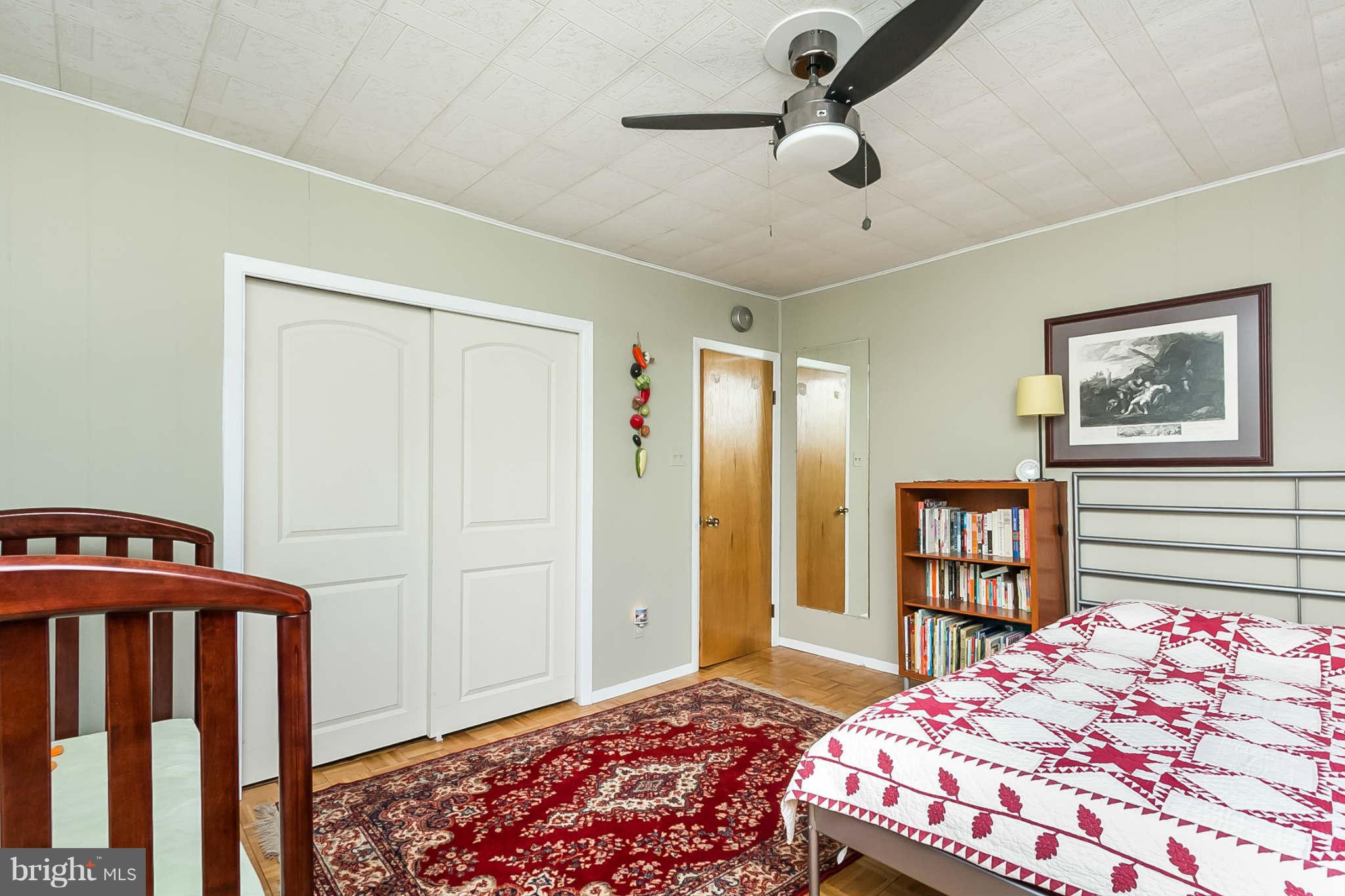 5506 Tramore Road Baltimore, MD 21214 - Photo 20 of 30 a bedroom with a bed closet and a book shelf