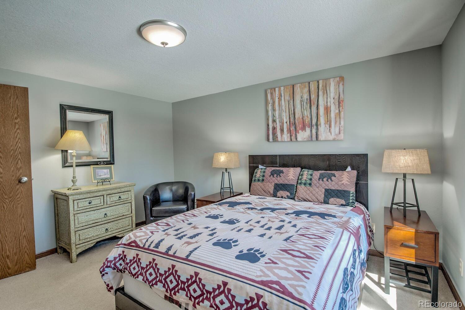 394 Co Road Fairplay, CO 80440 - Photo 25 of 46 a bedroom with a bed and a lamp on dresser
