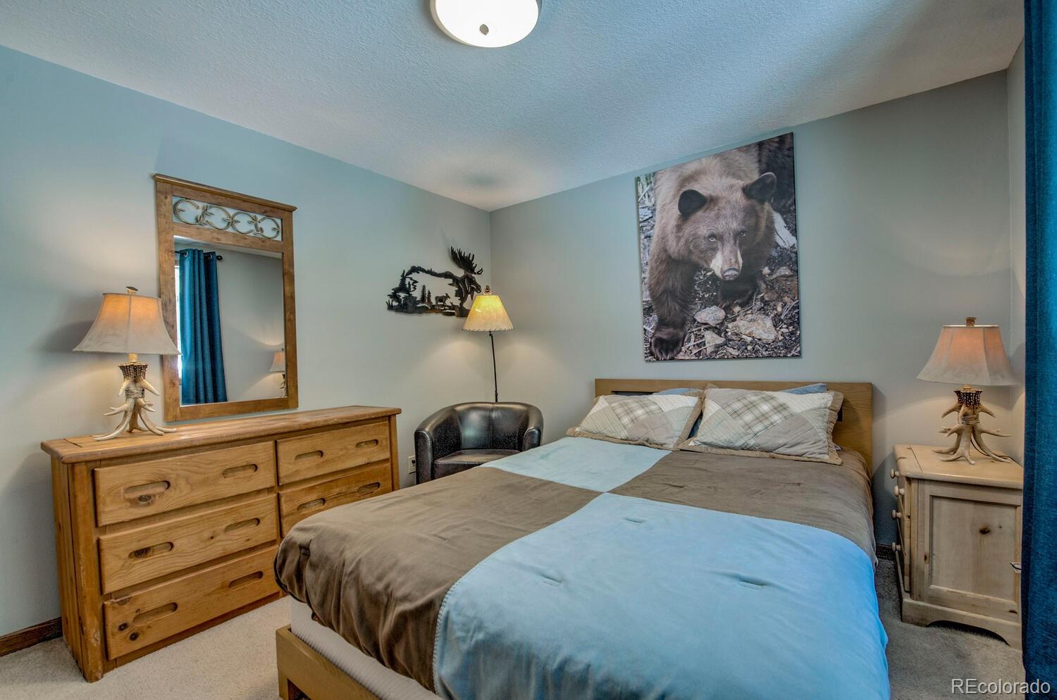 394 Co Road Fairplay, CO 80440 - Photo 28 of 46 a bedroom with a bed and a lamp on dresser