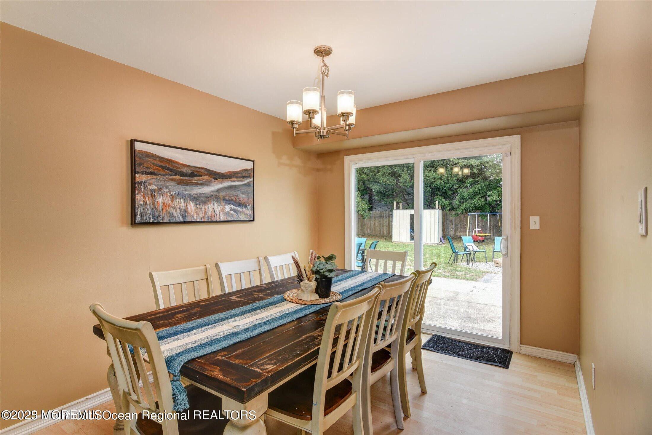 3 Albatross Drive Howell, NJ 07731 - Photo 5 of 16 a dining room with wooden floor a chandelier a wooden table and chairs