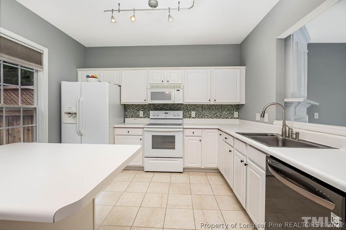 5441 Golden Arrow Lane Raleigh, NC 27613 - Photo 12 of 26 a kitchen with granite countertop a sink stove and refrigerator