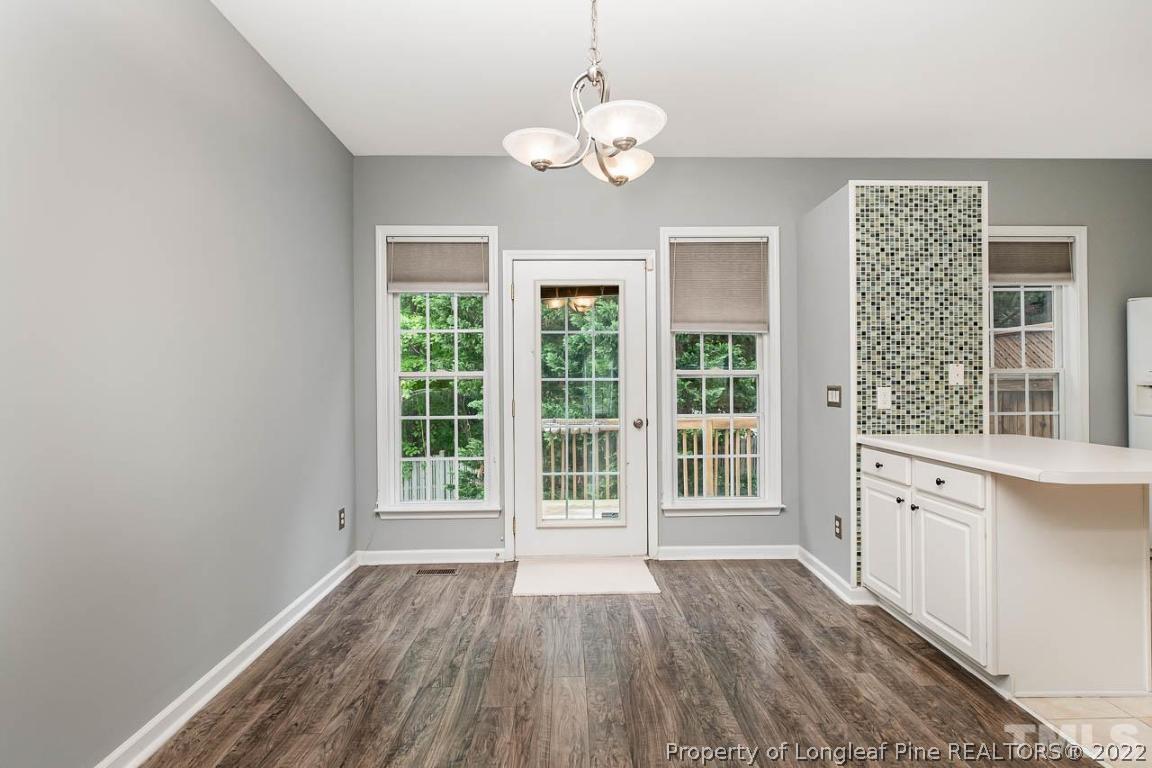 5441 Golden Arrow Lane Raleigh, NC 27613 - Photo 9 of 26 a view of an empty room with wooden floor and a window