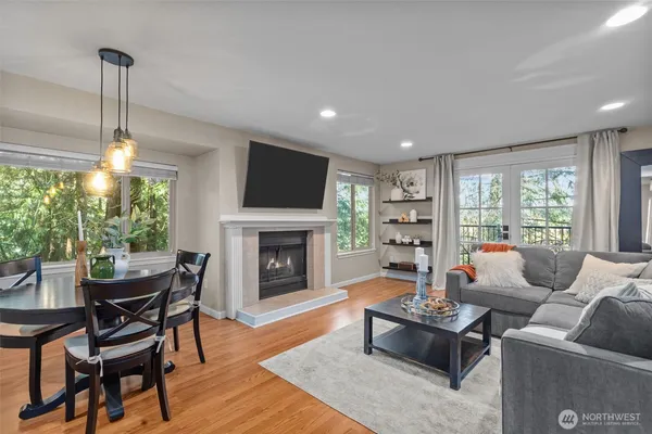 a living room with furniture a fireplace and a floor to ceiling window