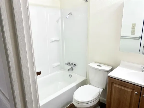 a white toilet sitting next to a bathroom sink and vanity