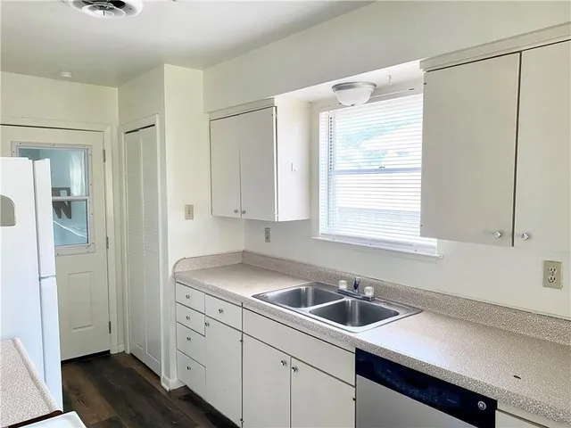 a view of a kitchen with a sink and dishwasher next to a window
