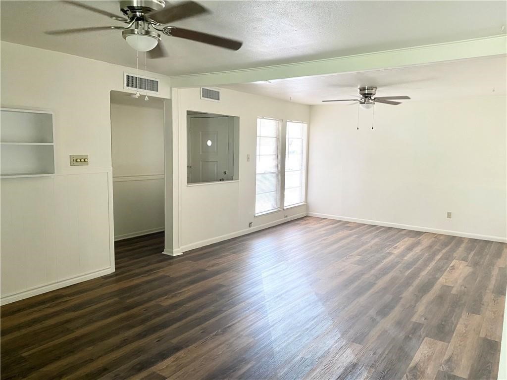 1728 Denver Street Portland, TX 78374 - Photo 3 of 15 an empty room with wooden floor fan and windows