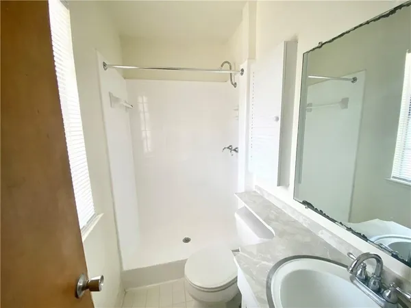 a bathroom with a granite countertop sink toilet and shower