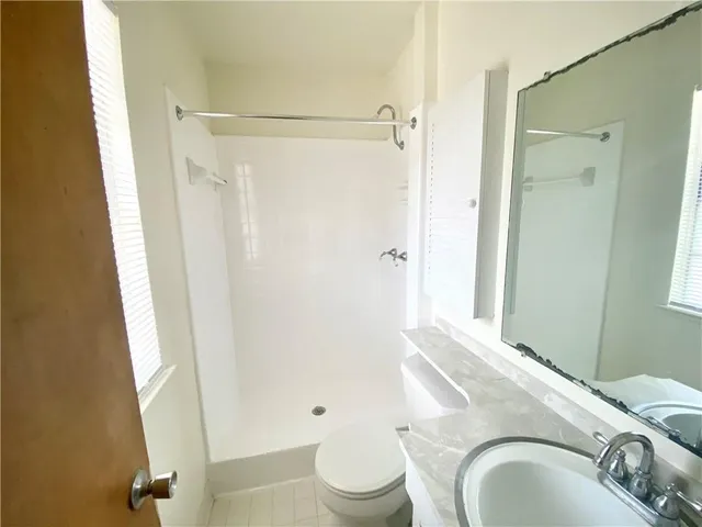 a bathroom with a granite countertop sink toilet and shower