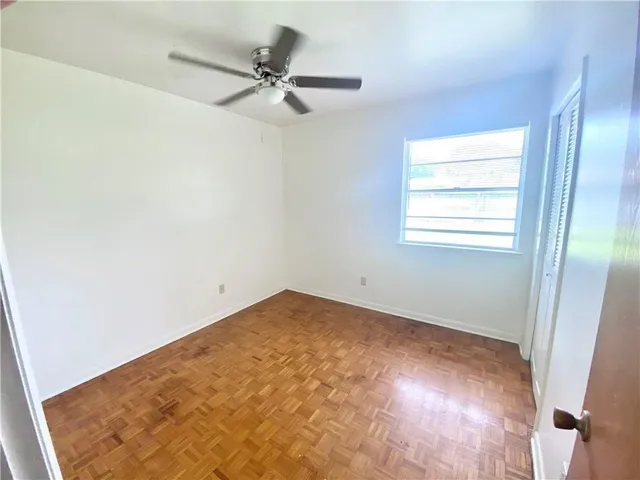 an empty room with a window and a fan