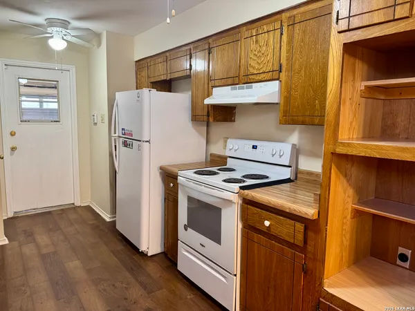 a kitchen with a refrigerator sink and cabinets