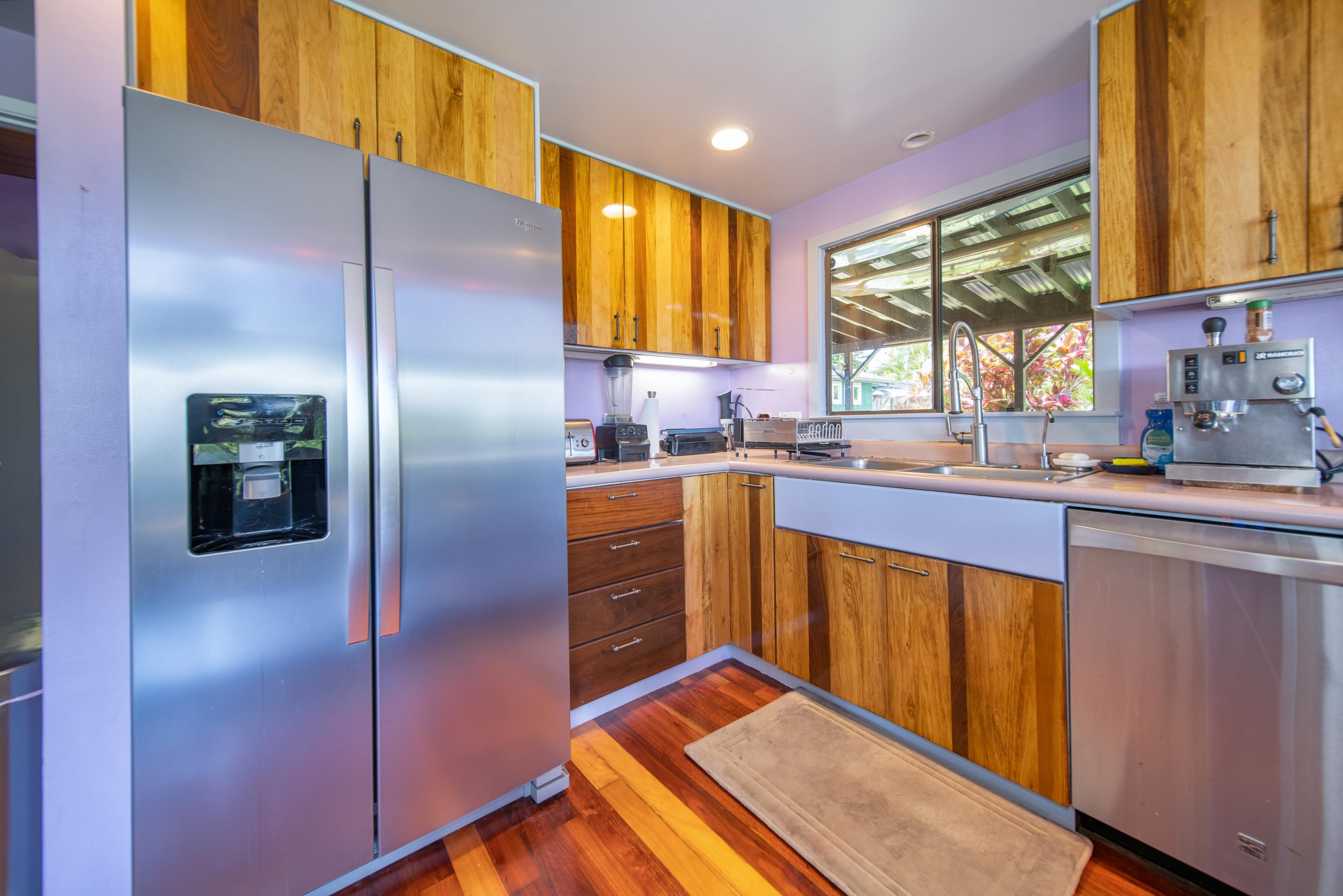 55 Oluolumau Place Haiku, HI 96708 - Photo 16 of 30 a kitchen with stainless steel appliances granite countertop a refrigerator a sink dishwasher a stove with wooden cabinets