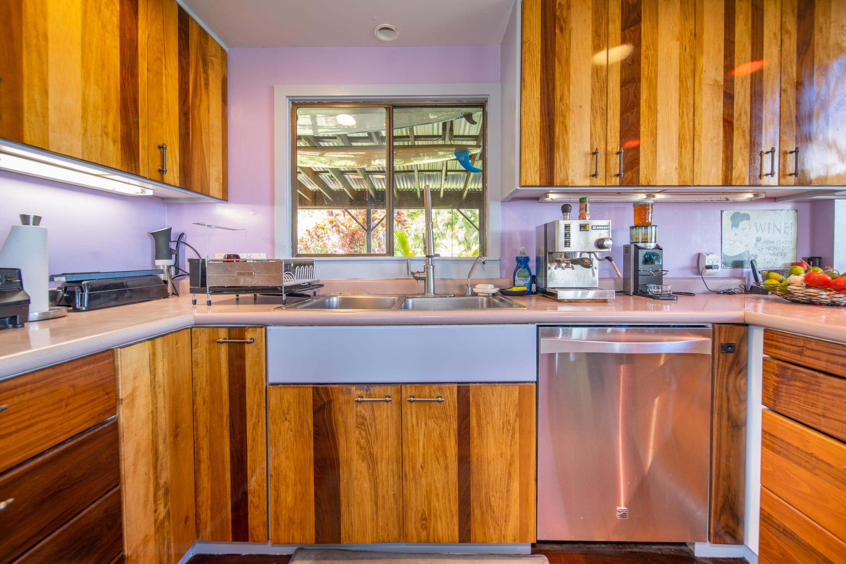 55 Oluolumau Place Haiku, HI 96708 - Photo 19 of 30 a kitchen with stainless steel appliances granite countertop wooden cabinets a sink and a window