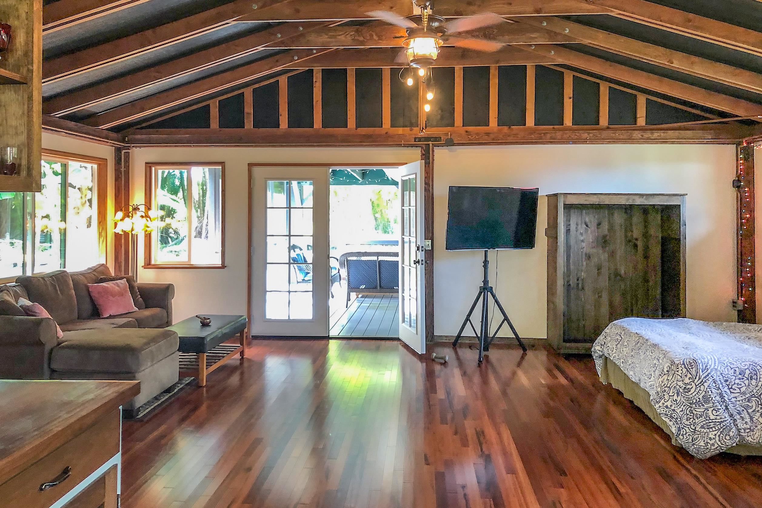 55 Oluolumau Place Haiku, HI 96708 - Photo 28 of 30 a living room with furniture a wooden floor and a flat screen tv
