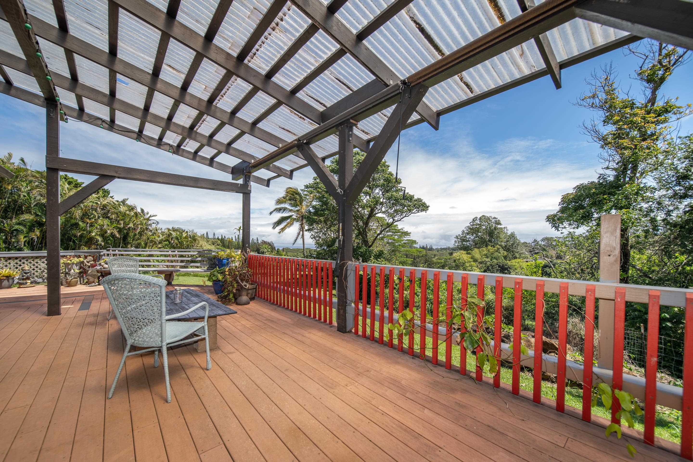 55 Oluolumau Place Haiku, HI 96708 - Photo 10 of 30 a balcony with wooden floor and outdoor seating