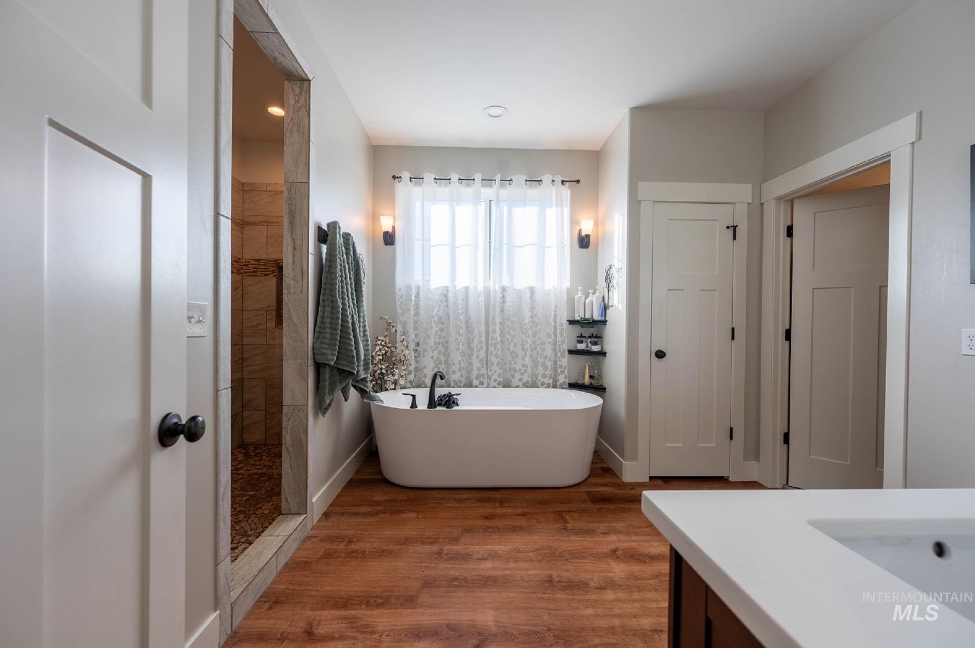 515 School Street Albion, ID 83311 - Photo 14 of 30 Full bathroom featuring vanity, a freestanding bath, walk in shower, and dark wood-style flooring