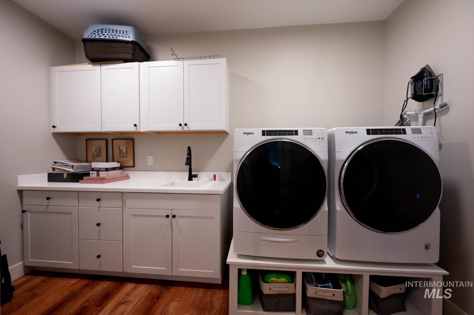 515 School Street Albion, ID 83311 - Photo 20 of 30 Washroom featuring dark wood-style flooring, washing machine and dryer, and cabinet space