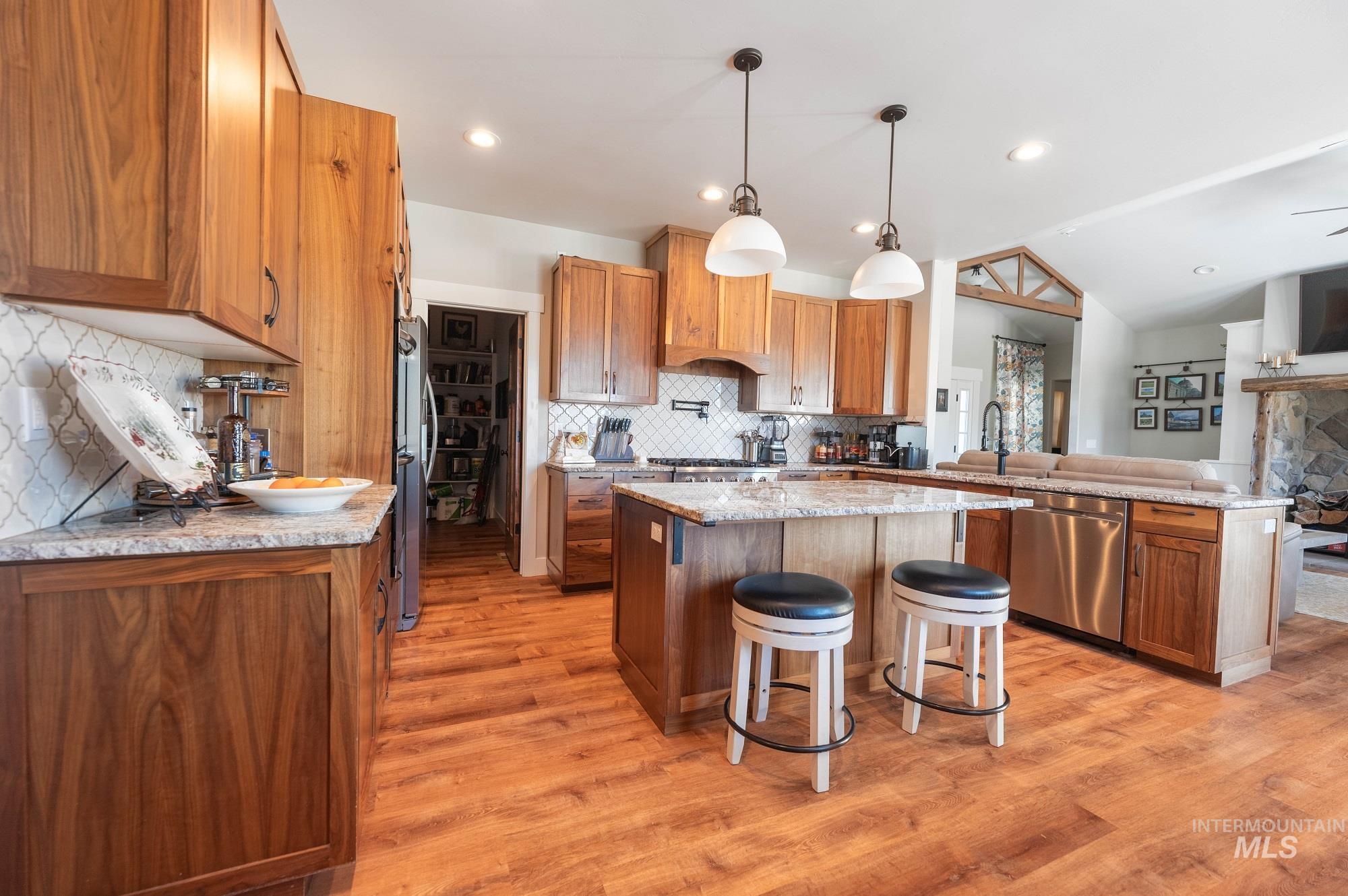 515 School Street Albion, ID 83311 - Photo 30 of 30 Kitchen featuring a kitchen breakfast bar, a peninsula, brown cabinets, hanging light fixtures, and open floor plan