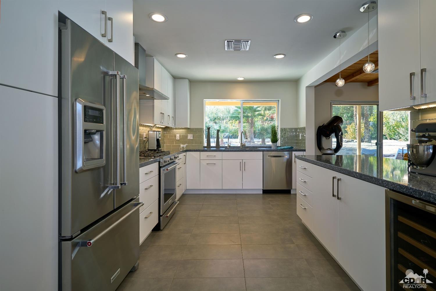71417 Mirage Road Rancho Mirage, CA 92270 - Photo 19 of 25 a kitchen with stainless steel appliances a sink a counter top space cabinets and a window