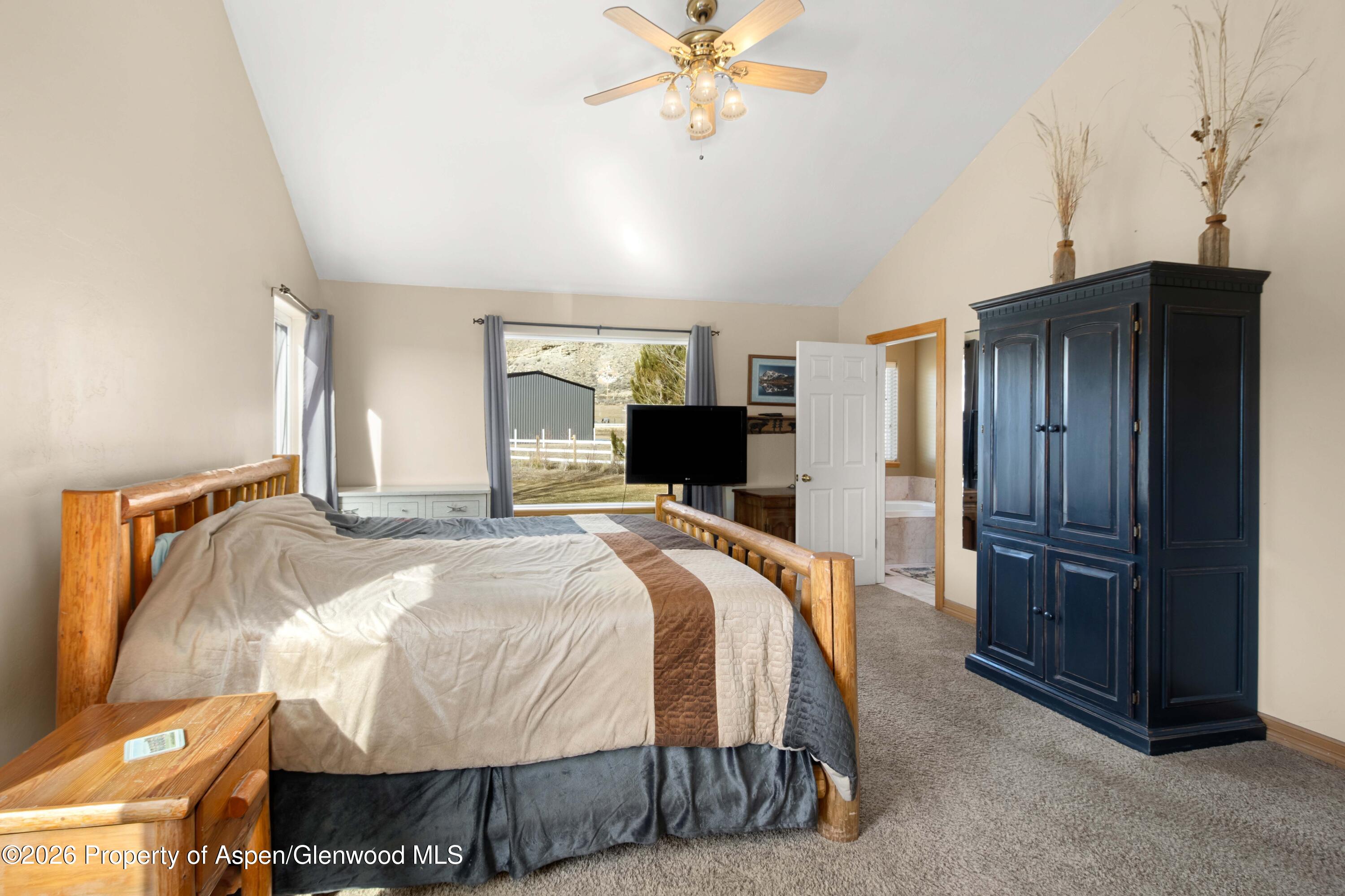 83 Native Springs Drive Rifle, CO 81650 - Photo 17 of 31 a bedroom with a bed and a chandelier