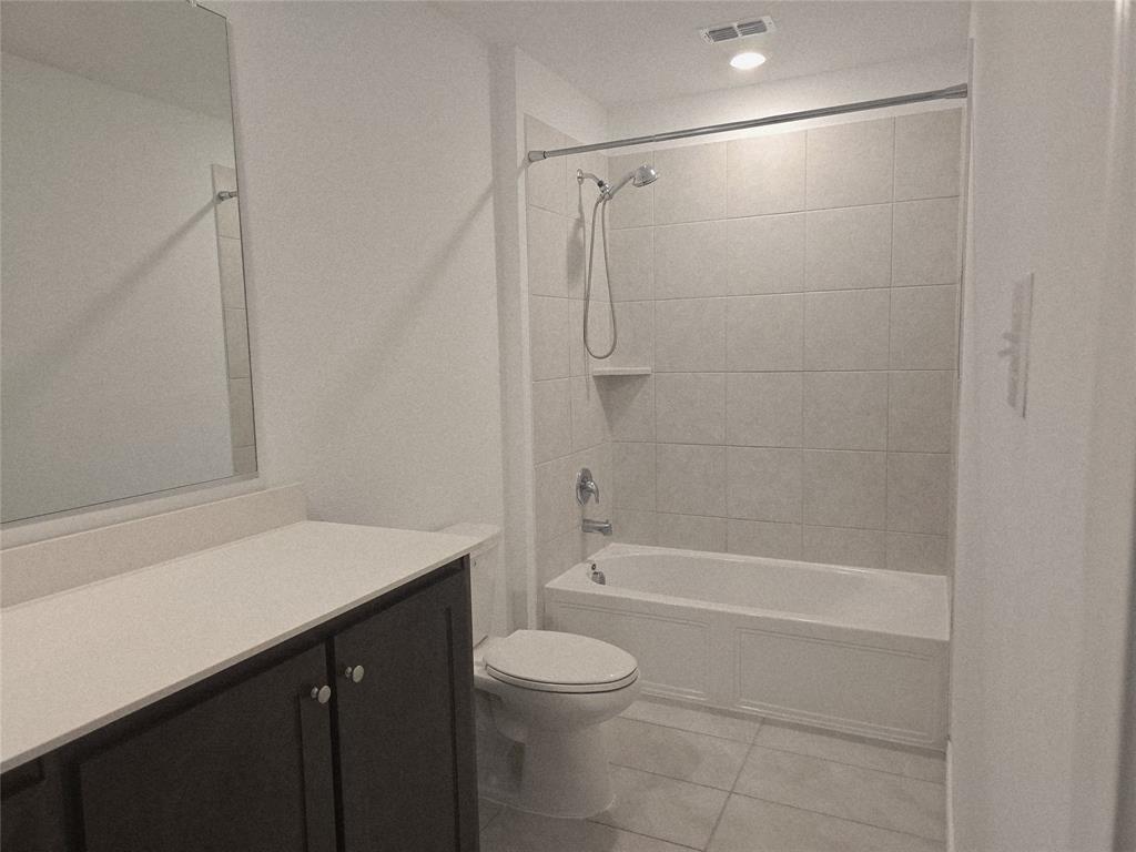 14017 Ilderton Street Pilot Point, TX 76258 - Photo 12 of 22 a bathroom with a granite countertop sink a toilet and shower