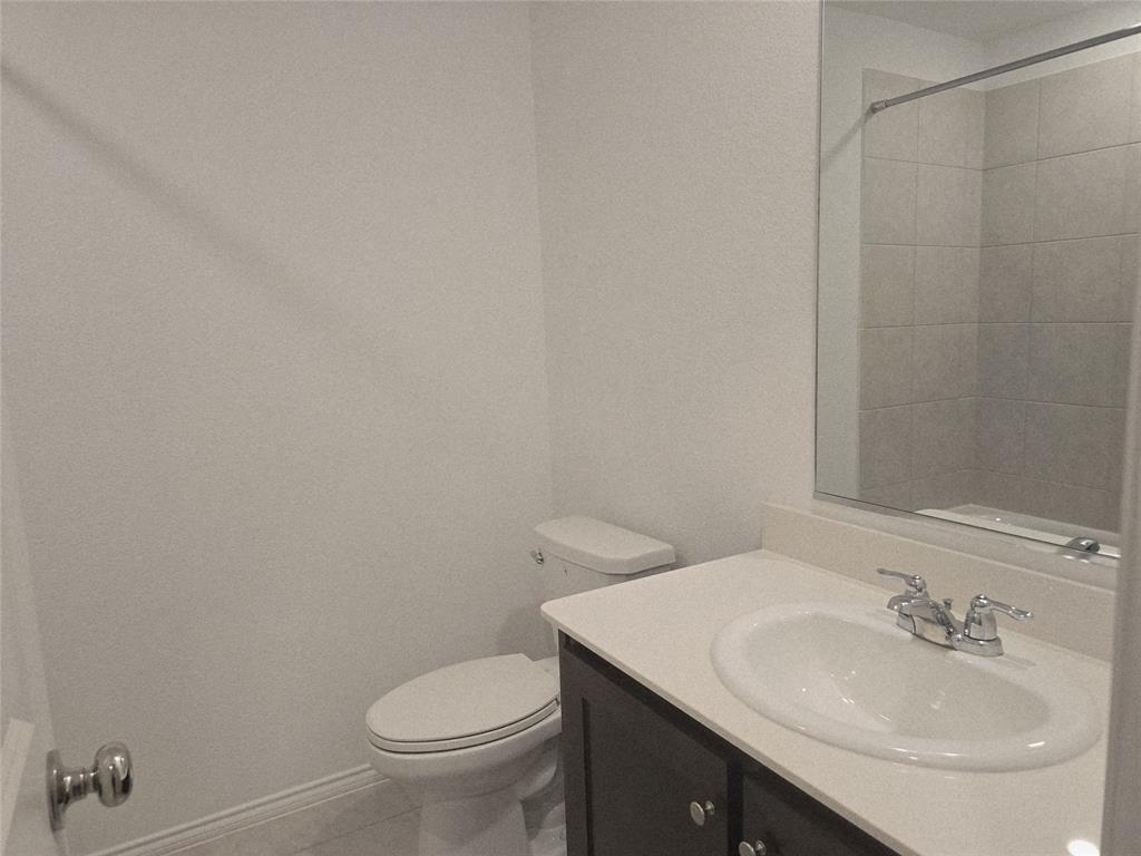 14017 Ilderton Street Pilot Point, TX 76258 - Photo 8 of 22 a bathroom with a sink toilet and a mirror