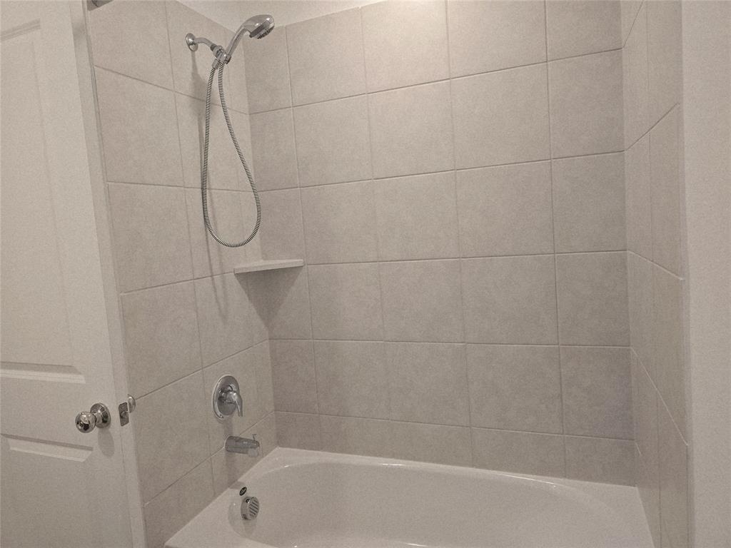 14017 Ilderton Street Pilot Point, TX 76258 - Photo 9 of 22 a bathroom with a bath tub with a shower