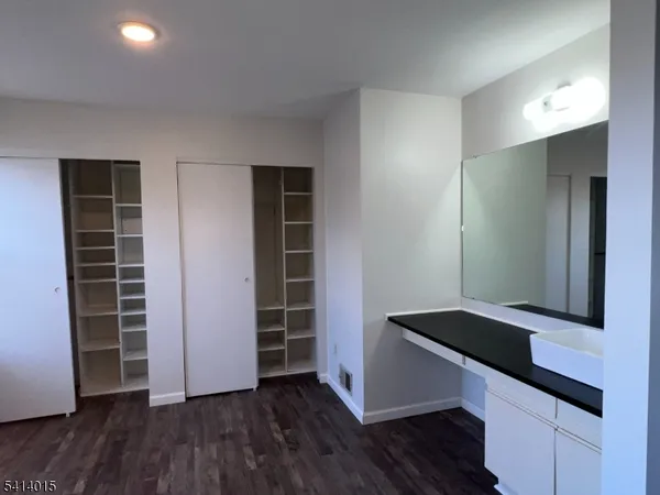 an empty room with wooden floor and closet