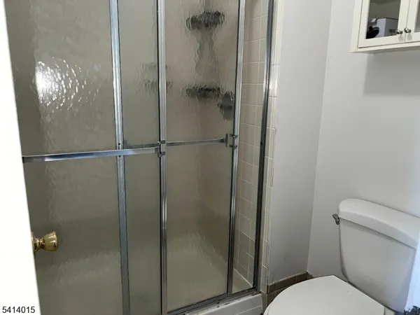 a bathroom with a granite countertop toilet and a shower