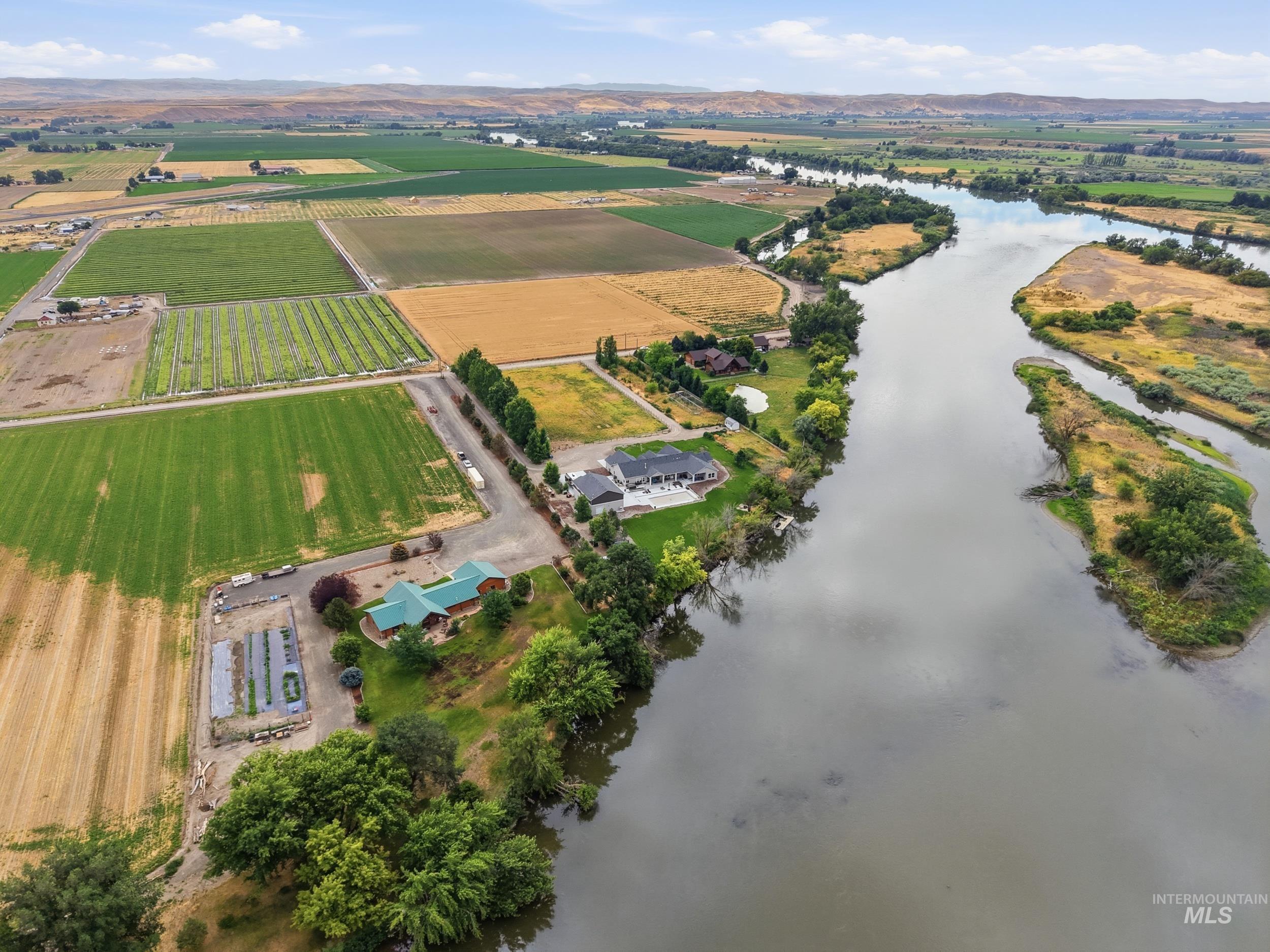 339 Airport Road Weiser, ID 83672 - Photo 39 of 49 Riverfront property featuring multiple structures, cultivated fields, and mature trees