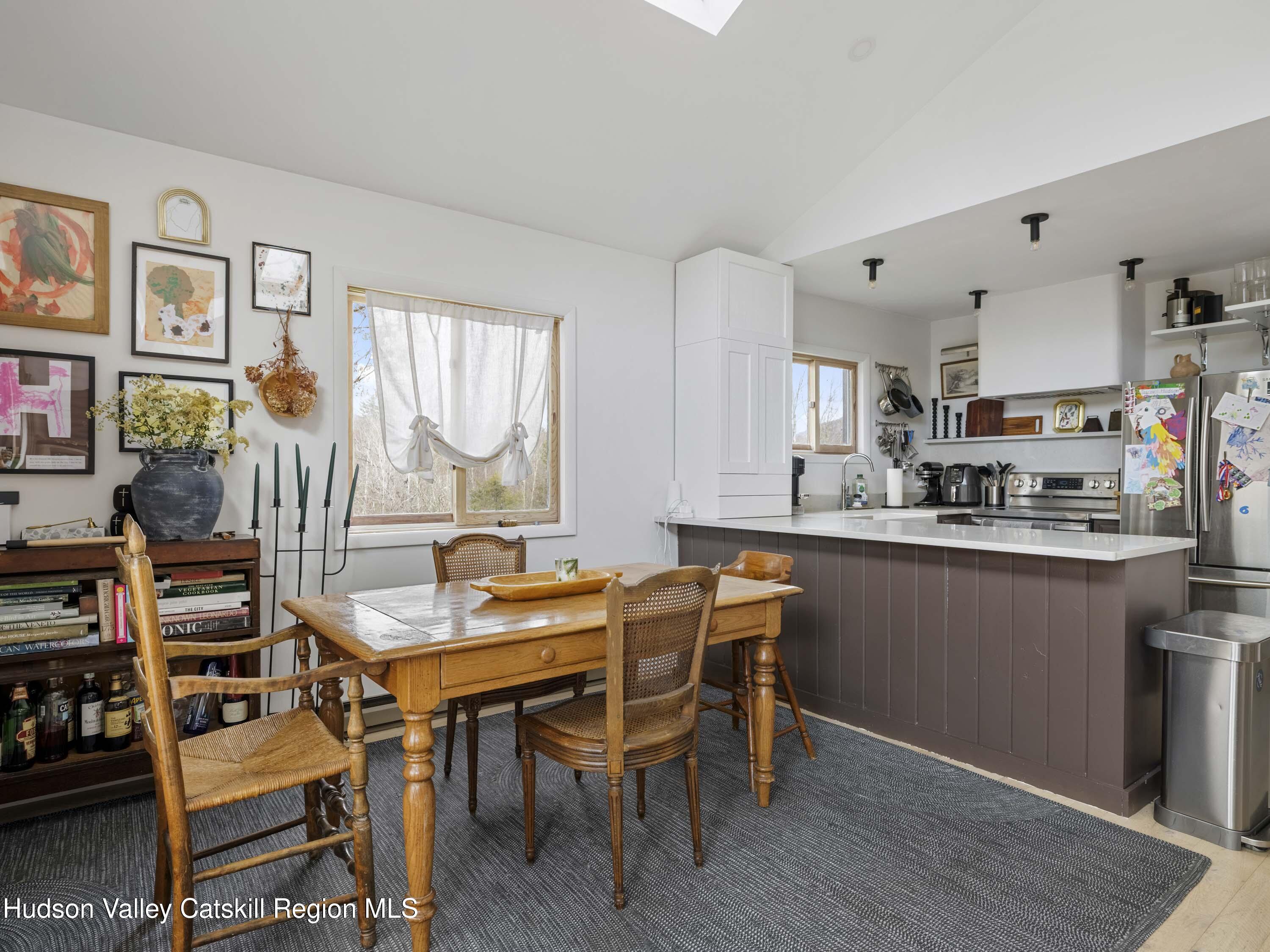 85 Bobillen Road Jewett, NY 12444 - Photo 12 of 59 a kitchen with stainless steel appliances kitchen island granite countertop a table chairs sink and cabinets