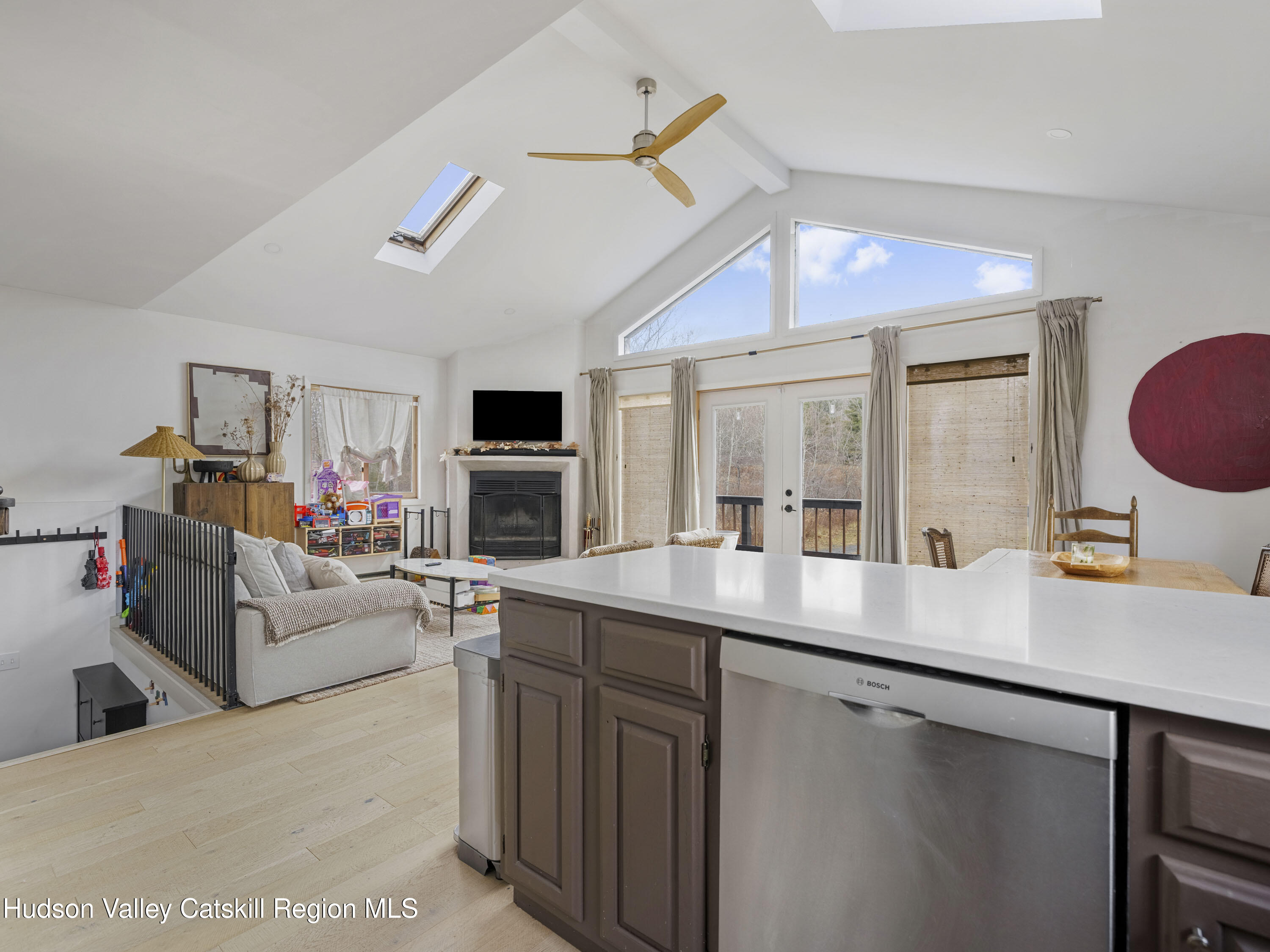 85 Bobillen Road Jewett, NY 12444 - Photo 18 of 59 a kitchen with a sink dishwasher a stove and a dining table with wooden floor