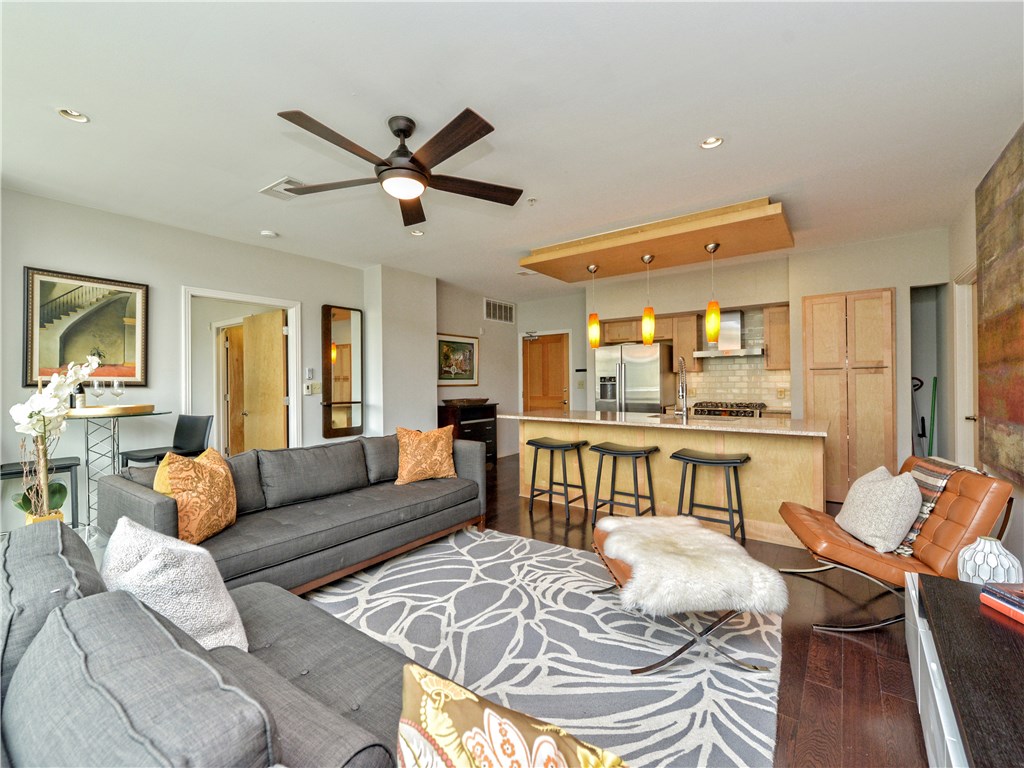 a living room with furniture and a view of kitchen