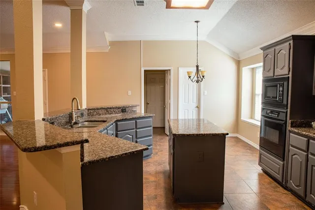 a kitchen with stainless steel appliances granite countertop a refrigerator a stove and a sink