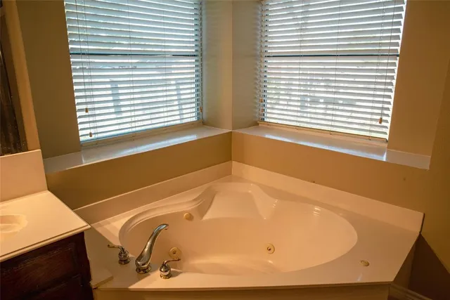 a bathroom with a bathtub and next to a window