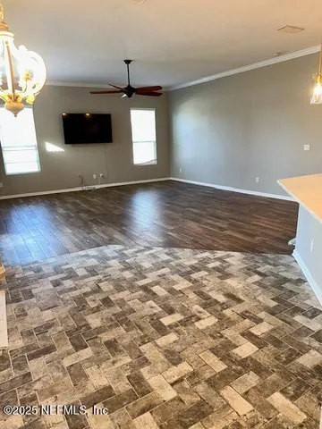 a view of a livingroom with wooden floor and a ceiling fan