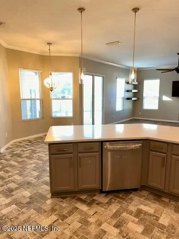 a kitchen with kitchen island a sink granite counter tops and a window