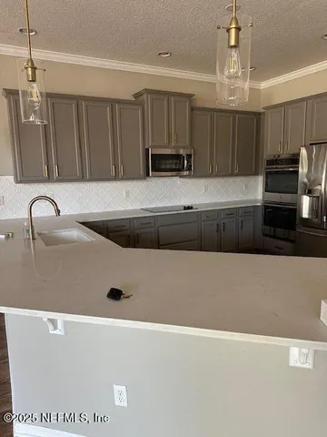 a kitchen with kitchen island a sink a stove and cabinets