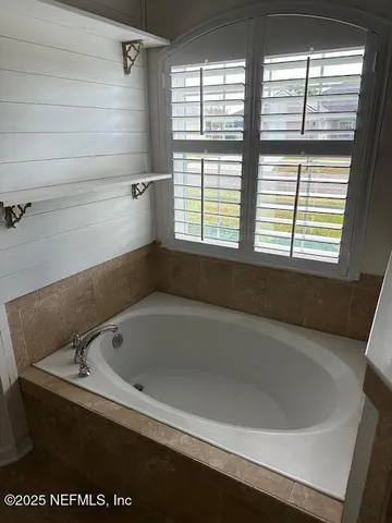 a bath tub sitting in a bathroom next to a window