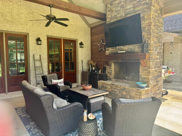 a outdoor living space with furniture and flat screen tv