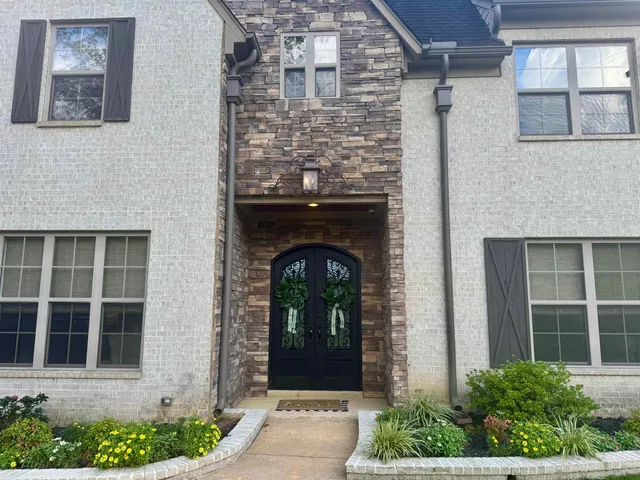 a front view of a house with potted plants